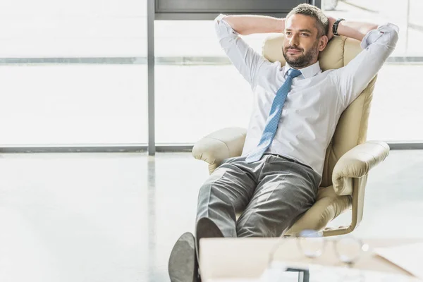 Handsome businessman relaxing on luxury armchair at modern office — Stock Photo