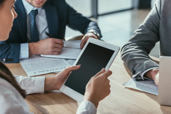 Cropped shot of businesswoman holding tablet with blank screen during meeting — Stock Photo