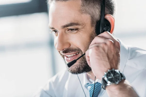 Happy adult support hotline worker with microphone at work — Stock Photo