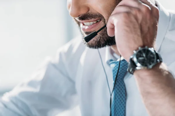 Tiro recortado de suporte hotline trabalhador na camisa com gravata falando por fones de ouvido com microfone — Fotografia de Stock