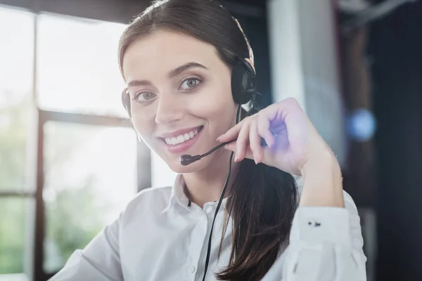 Schöne Callcenter-Mitarbeiterin mit Kopfhörern, die in die Kamera schaut — Stockfoto