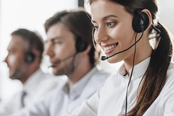 Lächelnde junge Callcenter-Managerin arbeitet mit Kollegen — Stockfoto