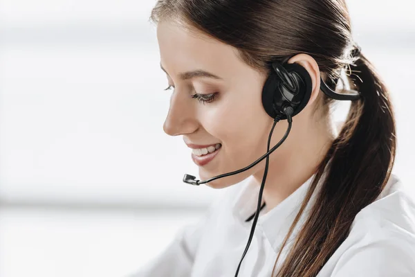 Beautiful female call center worker with headphones — Stock Photo