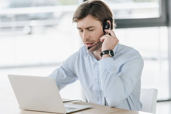 Fiducioso lavoratore call center con computer portatile seduto sul posto di lavoro — Foto stock