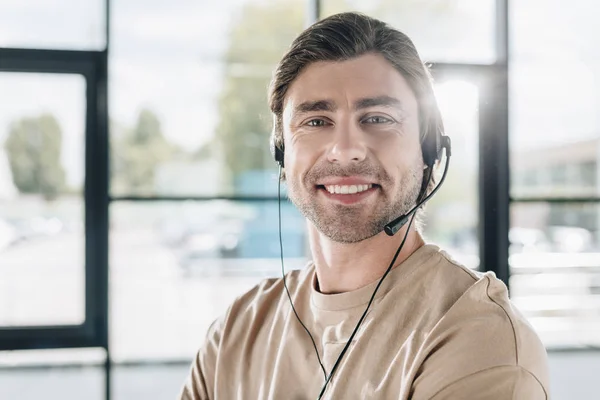 Primer plano retrato de sonriente joven trabajador de línea directa de apoyo con auriculares - foto de stock