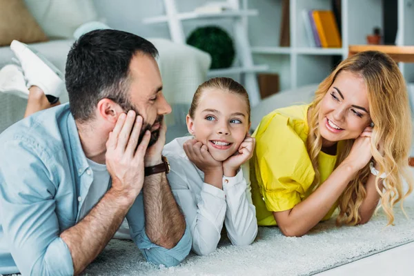 Happy young family lying on floor at home together — Stock Photo