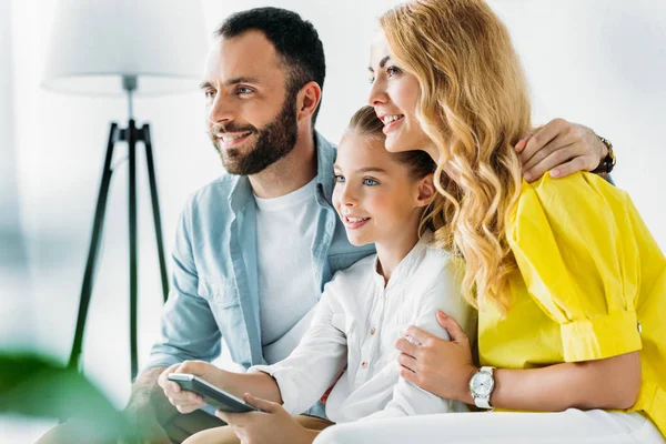 Feliz joven familia viendo la televisión juntos en casa - foto de stock