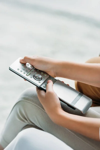 Cropped shot of child pressing button on tv remote control — Stock Photo