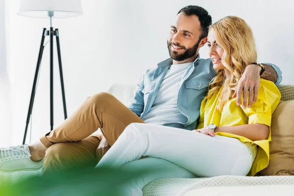 Beautiful couple relaxing on couch and watching tv at home — Stock Photo