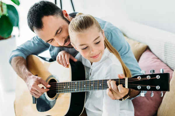 Happy father and daughter playing guitar together at home — Stock Photo