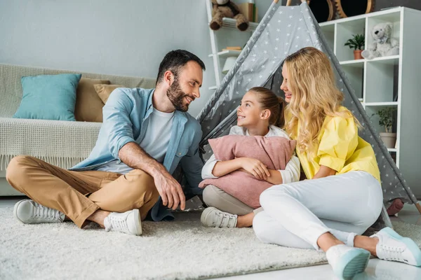 Heureux jeune famille assis sur le sol avec tipi — Photo de stock