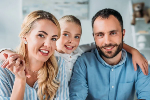 Glückliche junge Familie blickt in die Kamera — Stockfoto