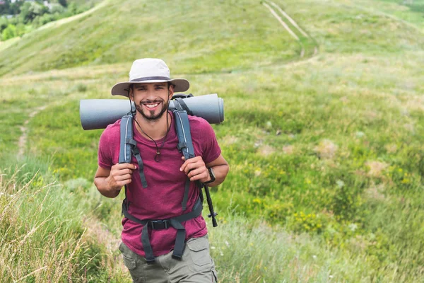 Viajero feliz en sombrero con mochila y alfombra turística - foto de stock