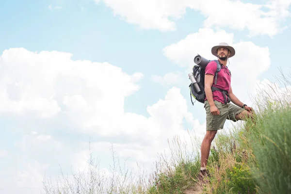 Caminante masculino en sombrero con mochila y alfombra turística - foto de stock