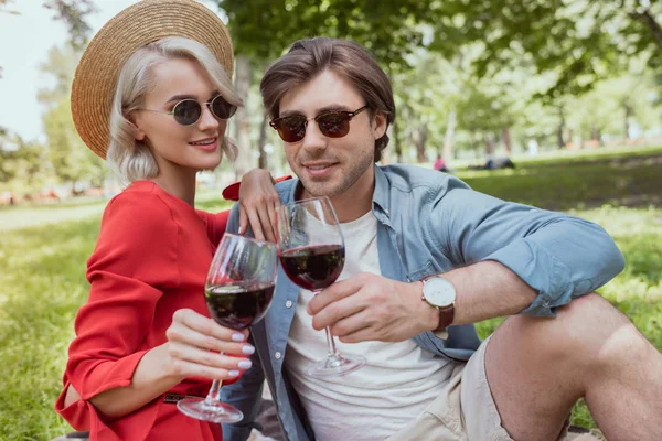 Casal feliz clinking com copos de vinho no parque — Fotografia de Stock