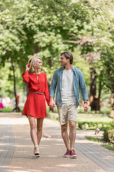 Petite amie et petit ami se tenant la main et marchant ensemble dans le parc — Photo de stock