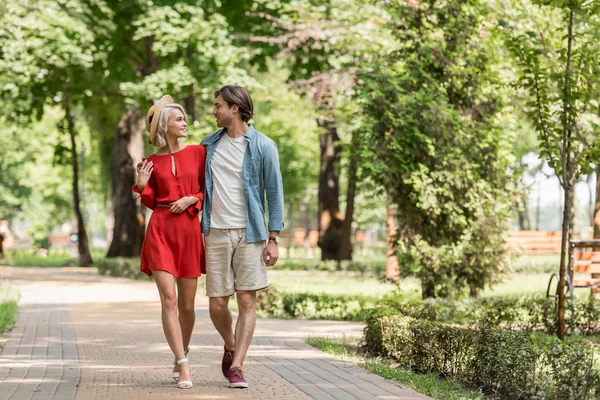 Fidanzata e fidanzato abbracciare e camminare insieme nel parco — Foto stock