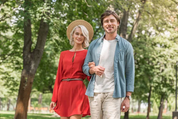 Namorada e namorado andando juntos no parque e olhando para a câmera — Fotografia de Stock