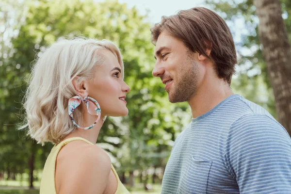 Vue latérale du couple se regardant dans le parc — Photo de stock