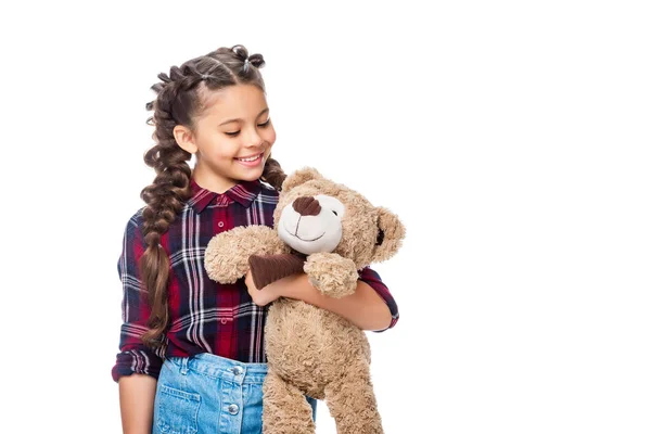 Smiling schoolchild holding teddy bear isolated on white — Stock Photo