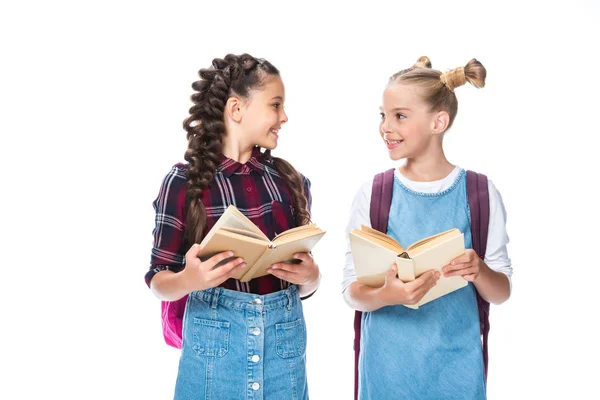 Schulkinder, die offene Bücher in der Hand halten und einander isoliert auf weiß anschauen — Stockfoto