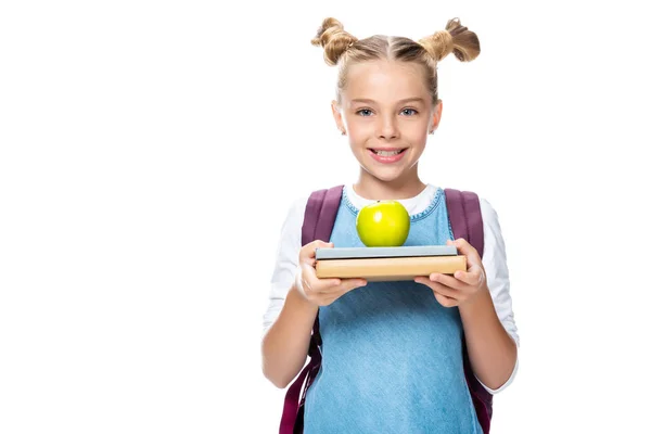 Niño en edad escolar sosteniendo manzana en libros aislados en blanco - foto de stock