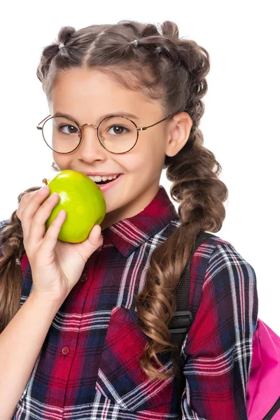 Lächelndes Schulkind beißt reifen Apfel isoliert auf weißem Grund — Stockfoto