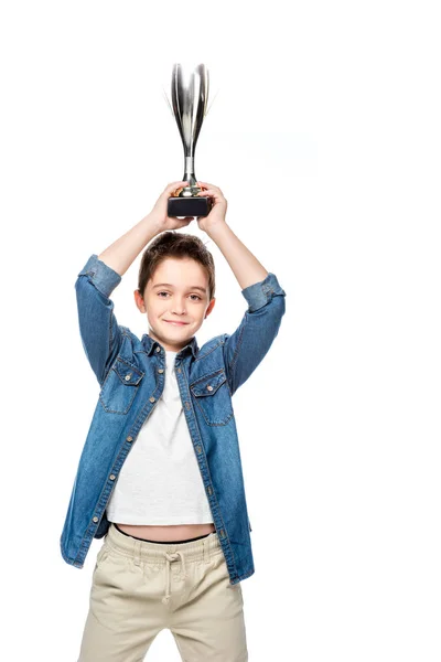 Schoolboy holding winner cup above head isolated on white — Stock Photo