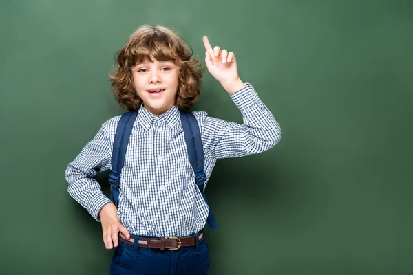 Schoolboy showing idea gesture near blackboard — Stock Photo