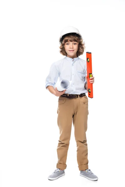 Schoolboy in costume of architect and helmet holding blueprints and bubble level isolated on white — Stock Photo