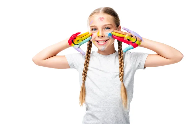 Smiling schoolchild showing painted hands with smiley icons isolated on white — Stock Photo