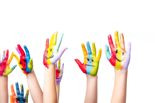 Imagem cortada de escolares mostrando as mãos pintadas com ícones sorridentes isolados no branco — Fotografia de Stock