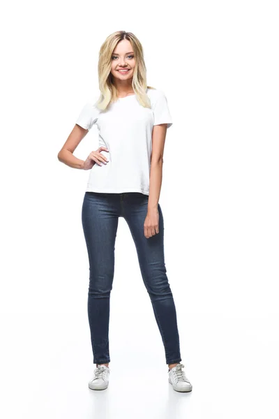 Усміхнена приваблива дівчина позує в білій сорочці і джинсах ізольована на білому — стокове фото