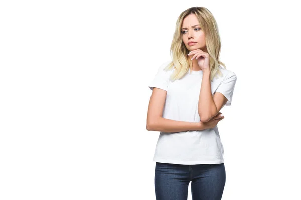Приваблива стомлена дівчина в білій сорочці і джинсах дивиться ізольовано на білому — стокове фото