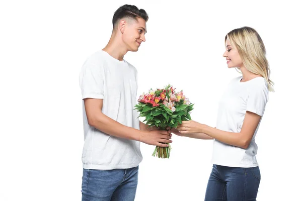Seitenansicht des Freundes präsentiert Blumenstrauß an Freundin isoliert auf weiß — Stockfoto