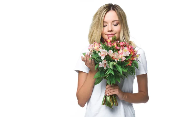 Attractive girl in white shirt sniffing bouquet of flowers with closed eyes isolated on white — Stock Photo