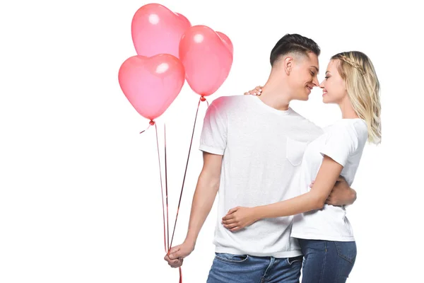 Couple going to kiss, boyfriend holding bundle of heart shaped balloons isolated on white — Stock Photo
