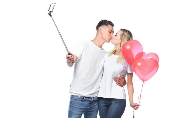 Casal beijando e tirando foto com smartphone e selfie stick isolado no branco — Fotografia de Stock