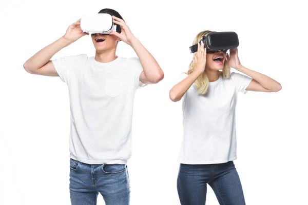 Casal animado usando fones de ouvido de realidade virtual isolados em branco — Fotografia de Stock