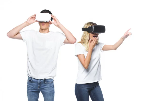 Casal surpreso usando fones de ouvido realidade virtual isolados em branco — Fotografia de Stock