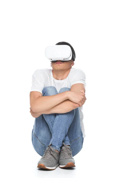 Schöner Mann im weißen Hemd sitzt verängstigt mit Virtual-Reality-Headset isoliert auf weißem Hintergrund — Stockfoto