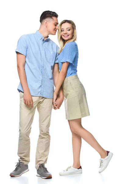 Sonriente pareja en azul camisas cogidas de las manos aisladas en blanco - foto de stock