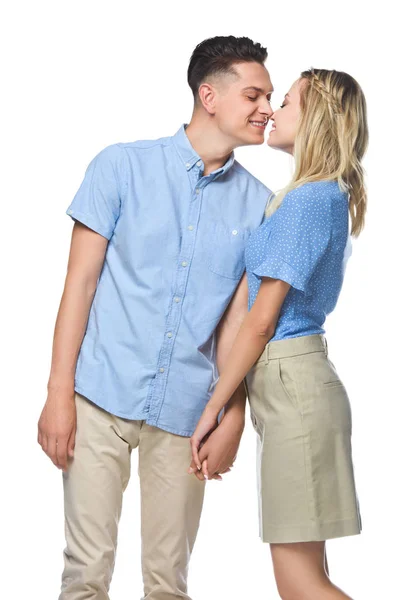 Sonriente pareja en azul camisas besos aislado en blanco - foto de stock