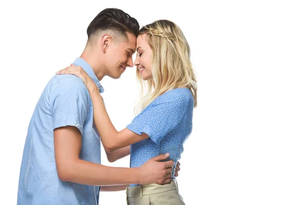 Couple in blue shirts hugging and touching with foreheads isolated on white — Stock Photo