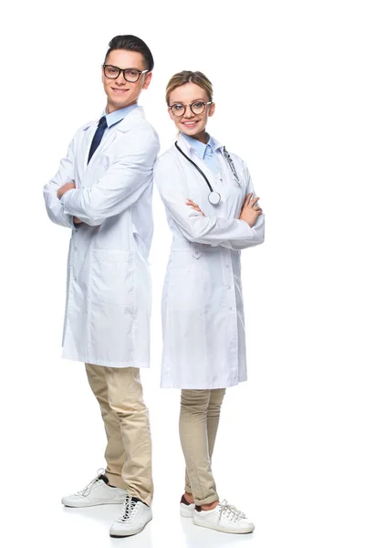 Doctors standing with crossed arms and looking at camera isolated on white — Stock Photo