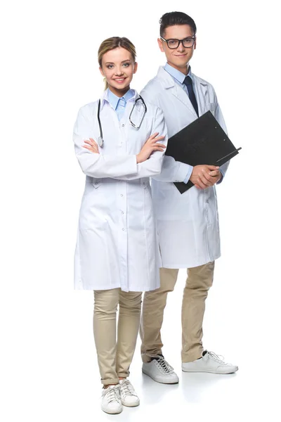 Médicos de pé com estetoscópio e área de transferência, olhando para a câmera isolada em branco — Fotografia de Stock