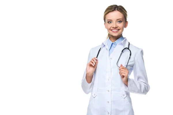 Привлекательный улыбающийся доктор в белом халате со стетоскопом, изолированный на белом — стоковое фото