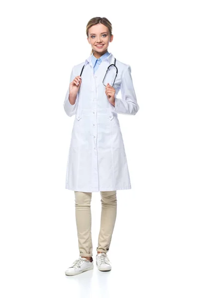 Young beautiful general practitioner in white coat with stethoscope, isolated on white — Stock Photo