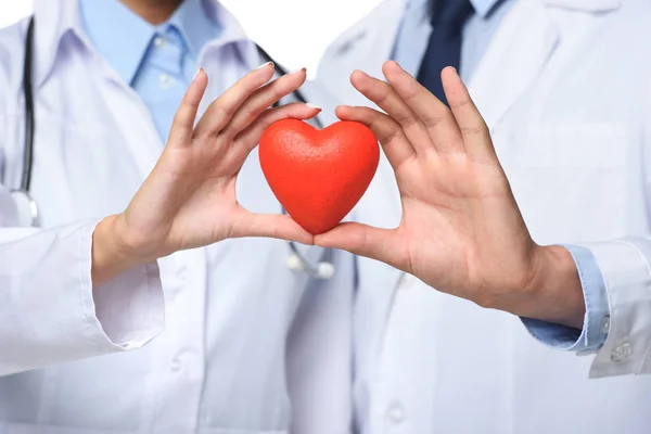 Vue partielle de deux médecins tenant le cœur rouge dans les mains, isolés sur blanc — Photo de stock