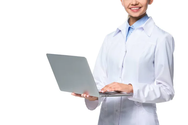 Vista ritagliata del medico donna in cappotto bianco utilizzando il computer portatile, isolato su bianco — Foto stock